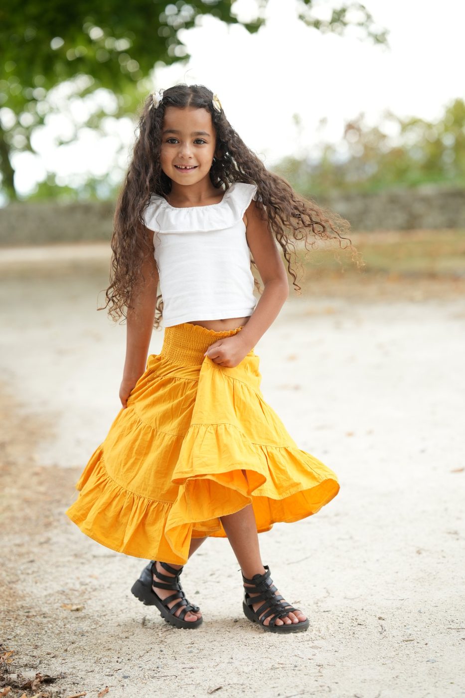 Petite fille qui fait tourner sa jupe jaune